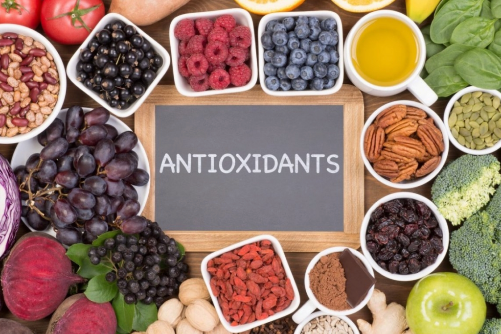 A colorful assortment of nutrient-dense Superfoods for Optimal Health, including berries, dark leafy greens, nuts, and seeds, displayed on a rustic wooden table.
